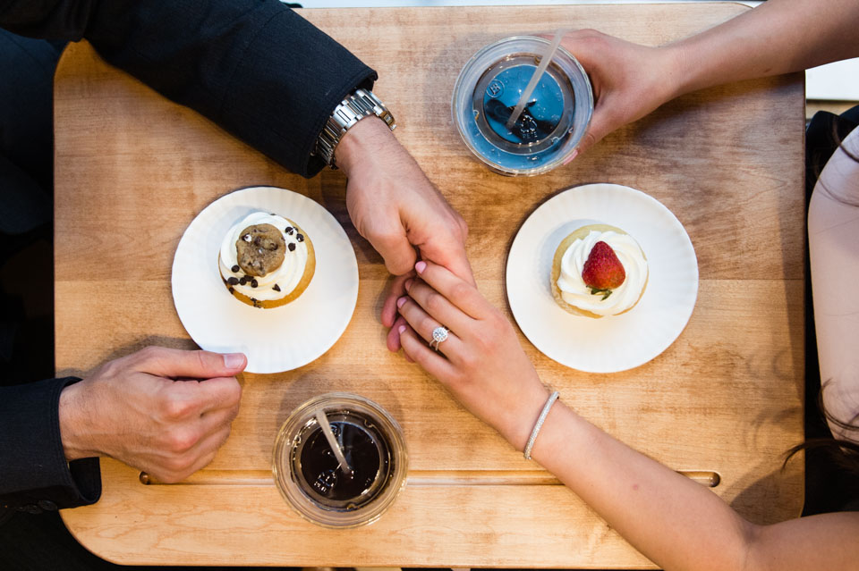 Hands reaching across the table with cupcakes