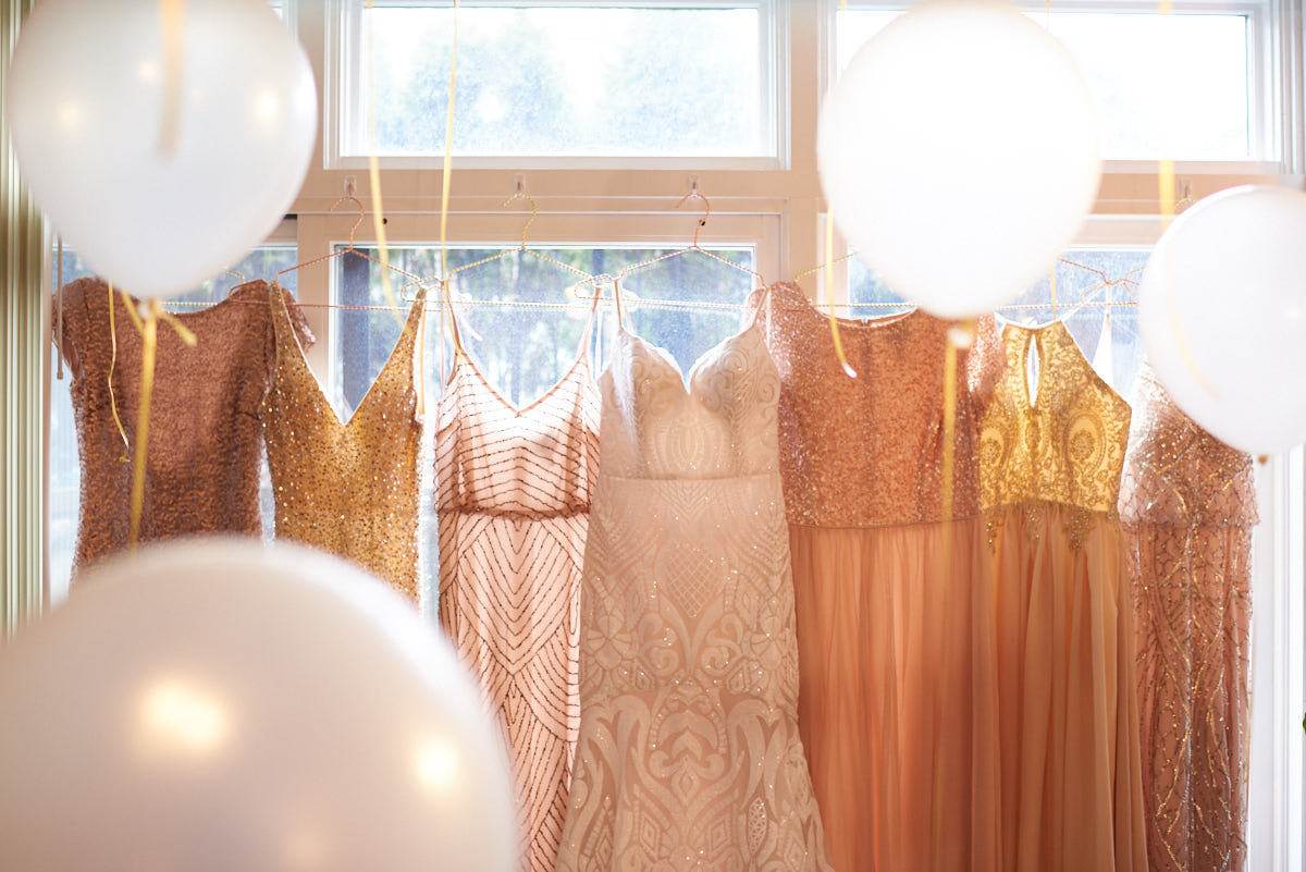 Bridesmaids and wedding dress hanging with balloons